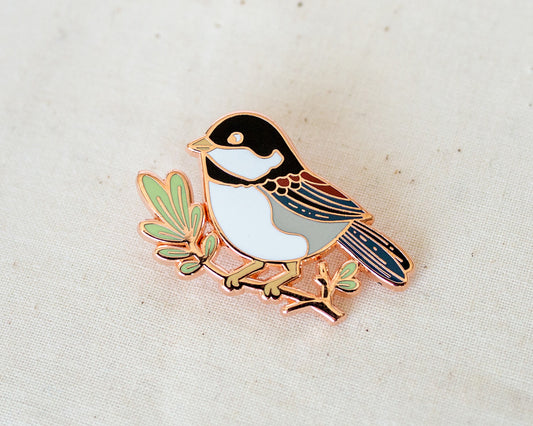 a cute little chickadee enamel pin in copper metal