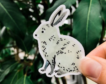 cute bunny rabbit animal sticker art by wildship studio held against plants