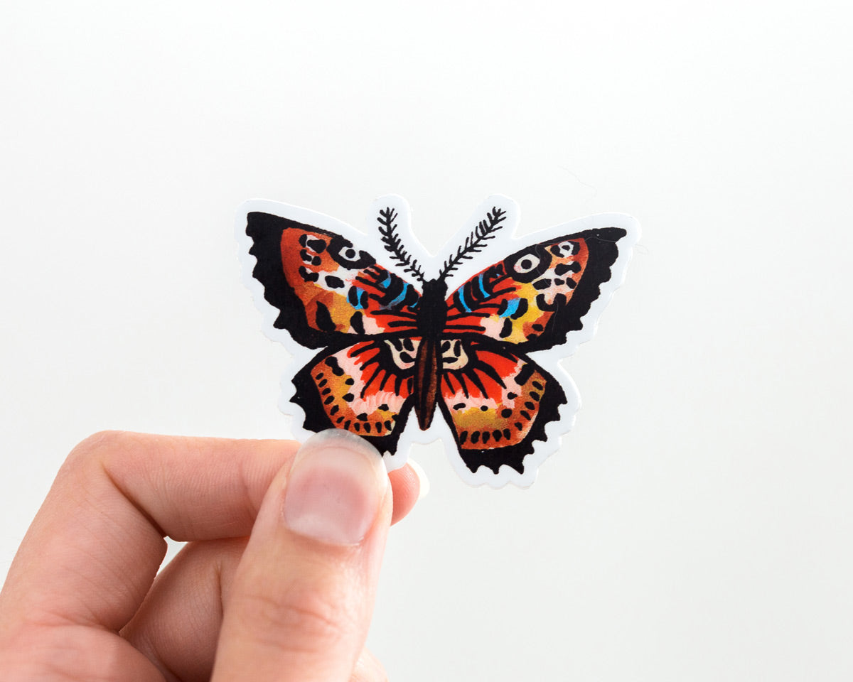 hand holding a cute butterfly vinyl sticker by wildship studio