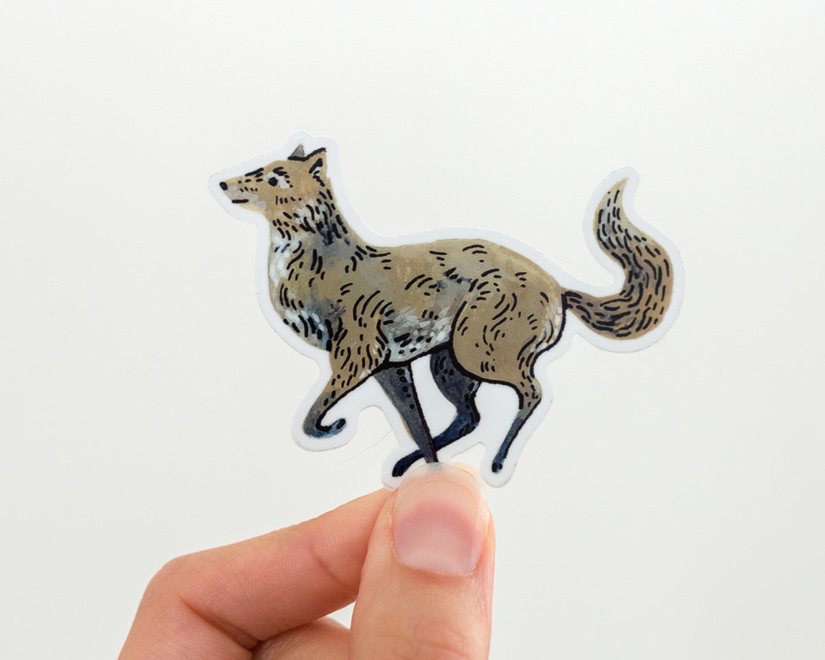 hand holding a cute wolf vinyl sticker by wildship studio