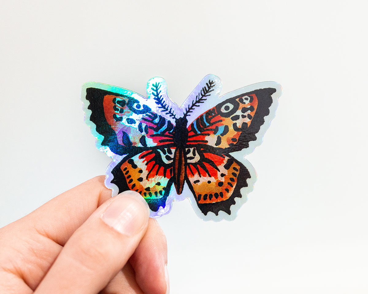 hand holding holographic butterfly vinyl animal sticker by wildship studio