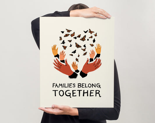 model holding protest sign of families belong together artwork