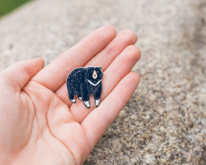 moon bear enamel pin held in palm of hand by wildship studio