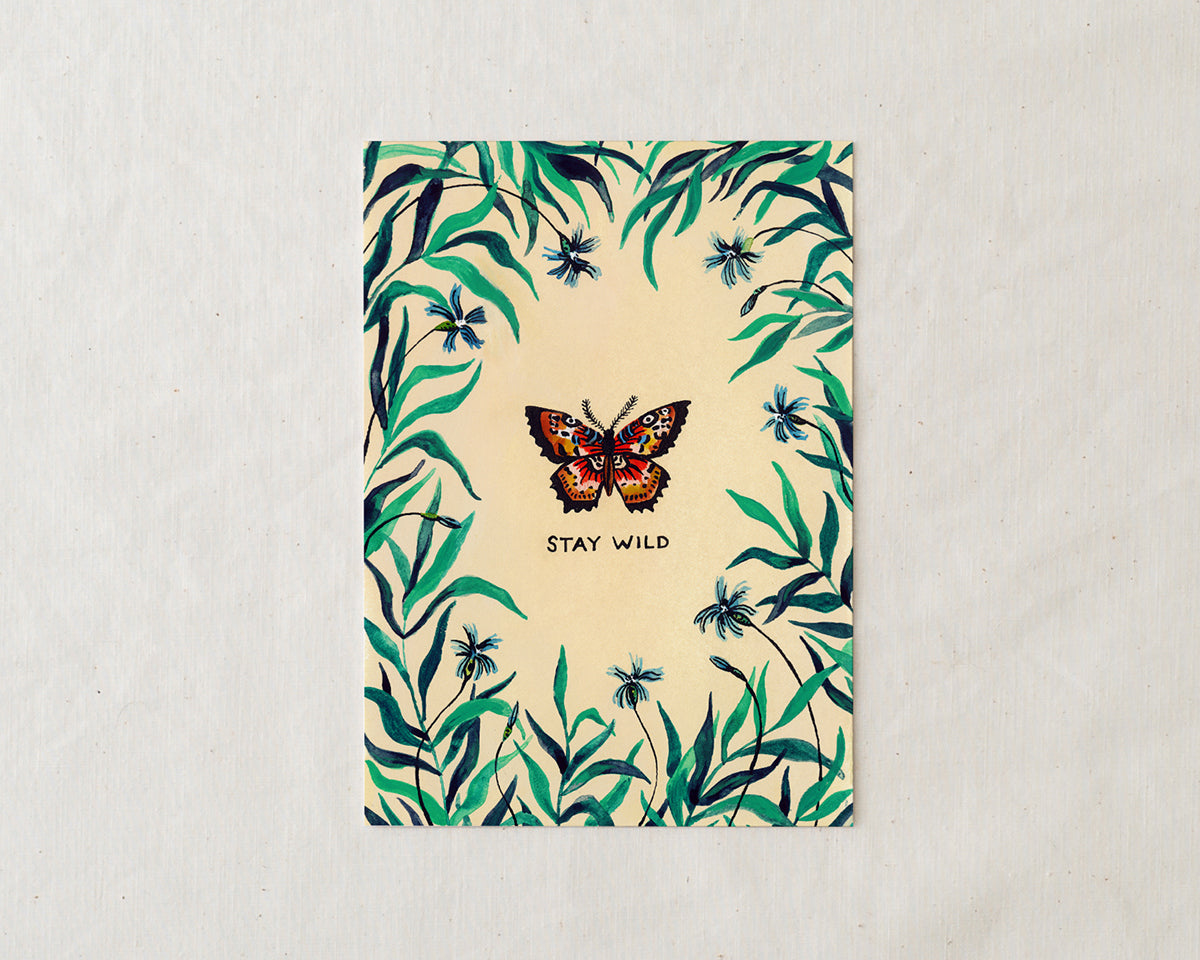 wildship studio art print of garden butterfly with green foliage and blue flowers and the words stay wild