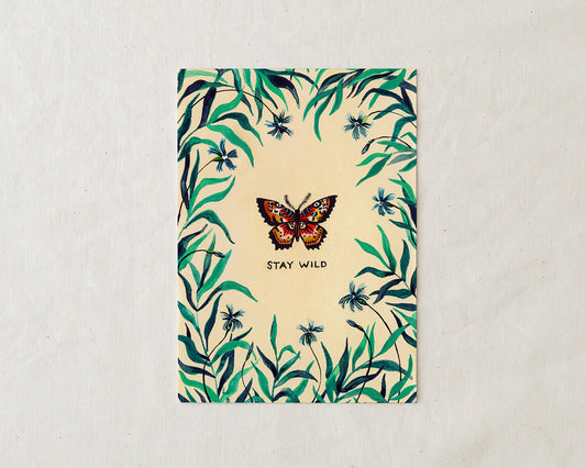 wildship studio art print of garden butterfly with green foliage and blue flowers and the words stay wild