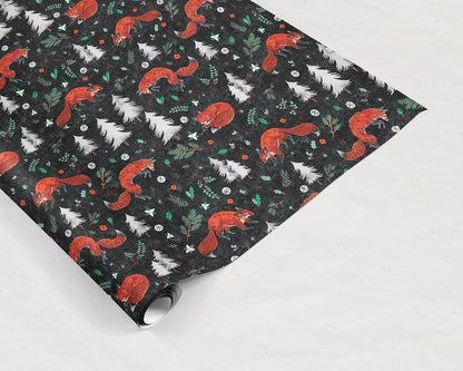 tilted wrapping paper sheet of Wildship Studio holiday gift wrap with fox, pine trees, snowflakes, poinsettia, and holly